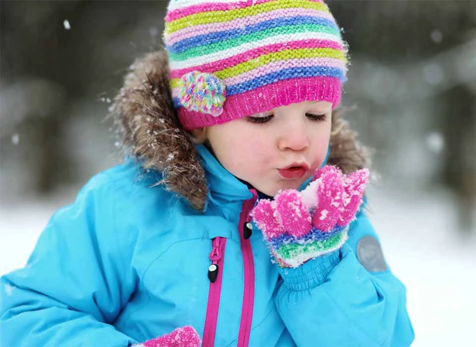 Kind mit Schnee in der Hand